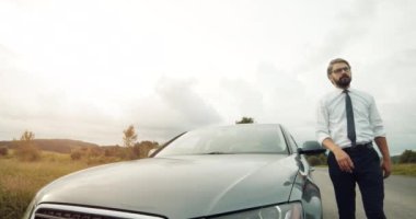 Uzun sürüş sırasında yolda mola veren bir iş adamı.