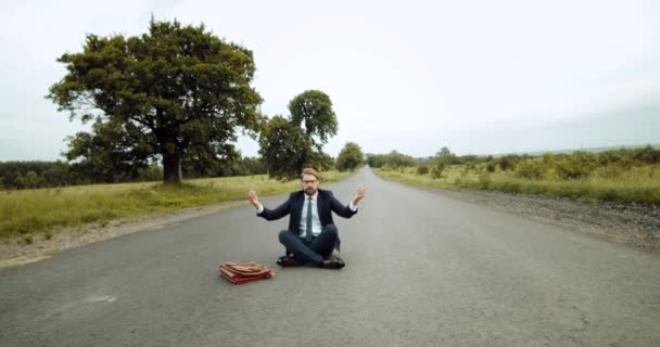 田舎道で瞑想黒スーツのハンサムな男 — ストック動画