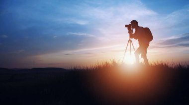 Gün batımı arkaplanında fotoğrafçı silueti