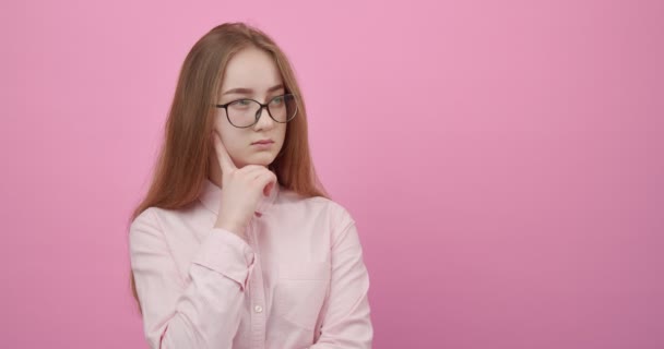 Tänksam flicka i glasögon tittar i avstånd i studio — Stockvideo