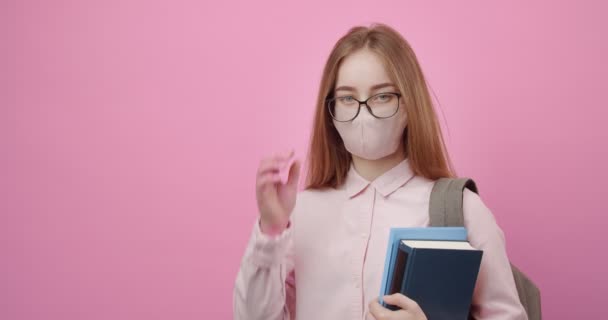 Student in medisch masker met boeken en rugzak in de studio — Stockvideo