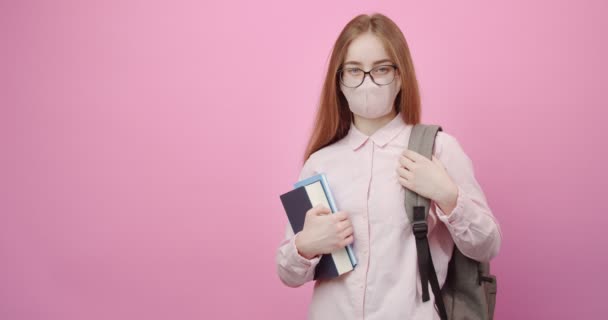 Portrait of student in medical mask with books and backpack — Stock Video