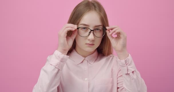 Young girl carefully looking into camera through eyeglasses — Stock Video