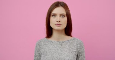 Stüdyoda poz verirken gülümseyen ve kameraya bakan kız