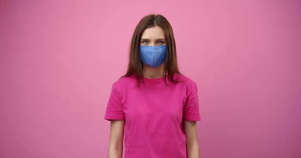 Chica responsable con máscara médica protectora en el estudio — Vídeo de stock