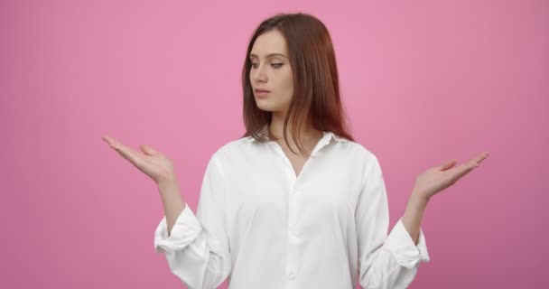 Чарівна дівчина в білій сорочці тримає руки з відкритими долонями — стокове відео