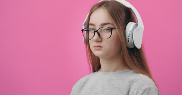 Ongelukkig meisje luisteren muziek in hoofdtelefoon in de studio — Stockvideo