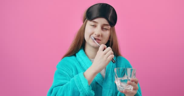 Menina sonolenta em roupão de banho escovar os dentes antes de ir para a cama — Vídeo de Stock