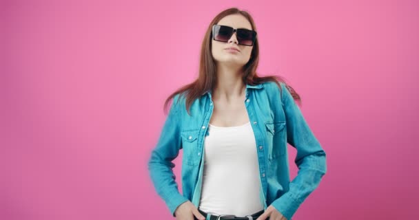 Приголомшлива жінка в модних сонцезахисних окулярах і джинсовій сорочці — стокове відео