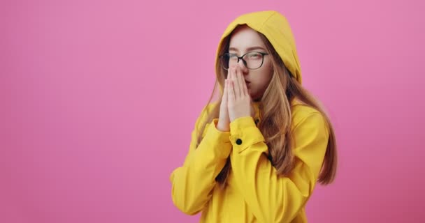 Vrouw in gele regenjas warmt zichzelf op tijdens regenachtige dag — Stockvideo