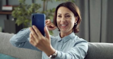 Akıllı telefondaki görüntülü konuşma sırasında el sallayan neşeli kadın