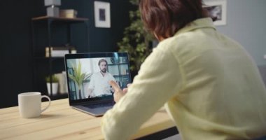 İki şirket üyesi laptopta konferans görüşmesi yapıyor.
