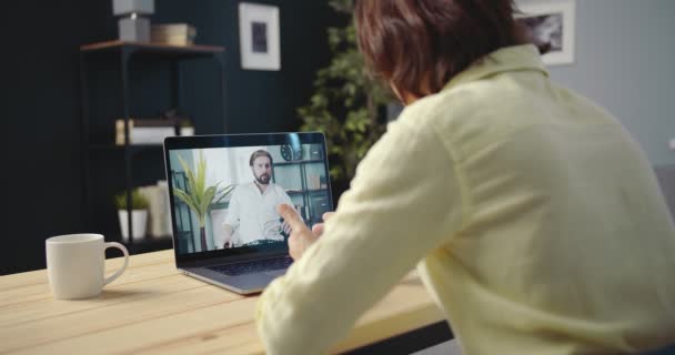 Два сотрудника компании проводят конференц-звонок на ноутбуке — стоковое видео