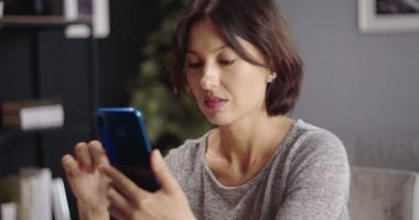 Güzel bir kadın evde otururken kullanıyor.