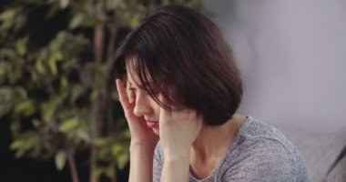 Evde baş ağrısı çeken olgun bir kadın.