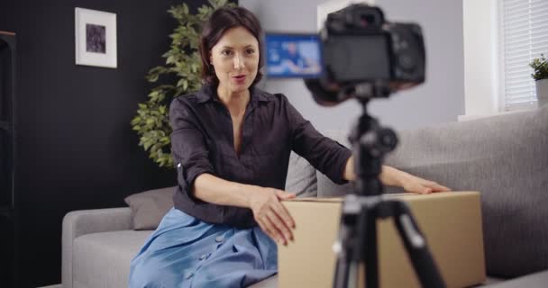 Happy woman shooting unpacking video on camera — Stok Video