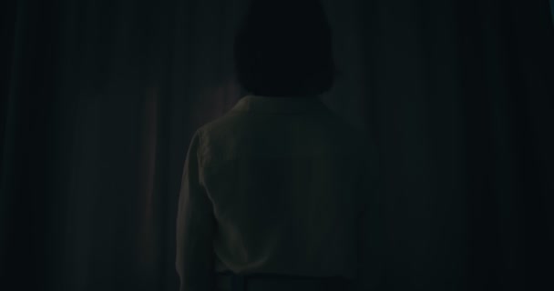 Zadní pohled na ženu otevírající závěsy v ložnici — Stock video