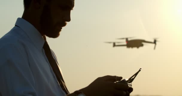 Vousatý muž v bílé košili a černé kravatě pomocí drone — Stock video