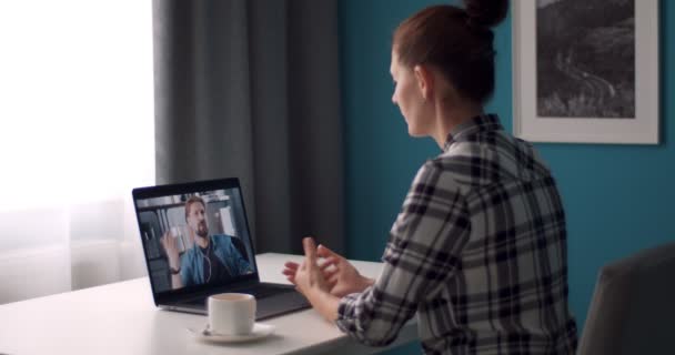 Женщина ведет видео-разговор с другом на ноутбуке — стоковое видео