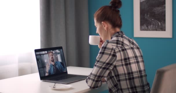 Жінка п'є каву під час онлайн-спілкування з чоловіком — стокове відео