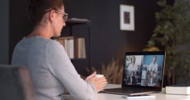 Video görüşmesi sırasında partnerlerle konuşan ve el kol hareketi yapan bir kadın.