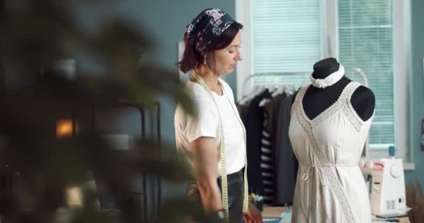 ドレスとマネキンの近くに立つ笑顔のデザイナー — ストック動画