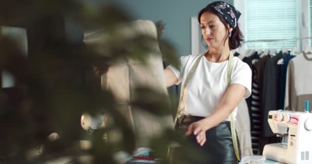 Mutlu kadın atölyedeki yeni koleksiyonun çizimlerine bakıyor. — Stok video