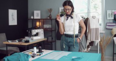 Moda tasarımcısı stüdyoda kalıp ve kumaşla çalışıyor.