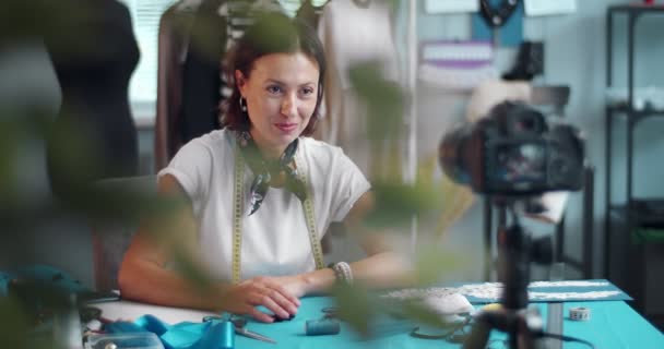 Kobieta siedząca przy stole z narzędziami do szycia i filmem wideo — Wideo stockowe