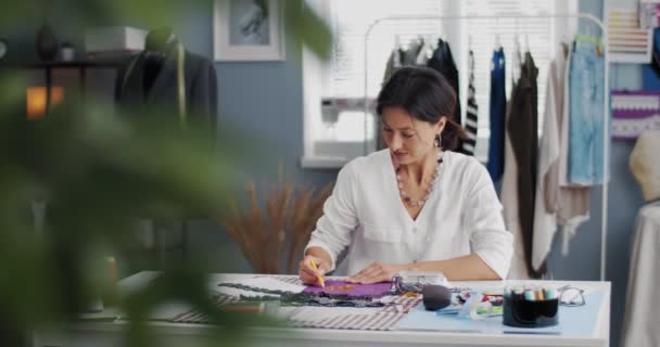 Aantrekkelijke vrouw tekent schetsen op eigen atelier — Stockvideo