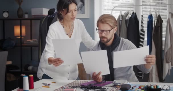 Diseñadores de moda trabajando con bocetos en un estudio luminoso — Vídeo de stock