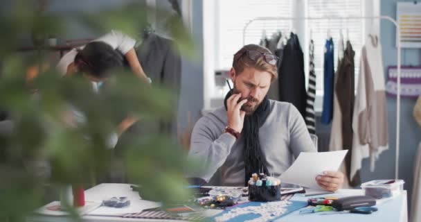 Pareja de diseñadores creando ropa de moda en el estudio — Vídeo de stock