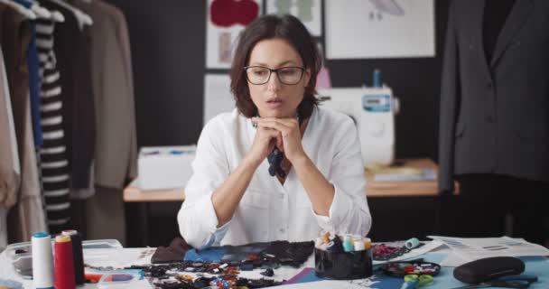Portret van uitgeputte vrouwelijke ontwerper zittend in studio — Stockvideo
