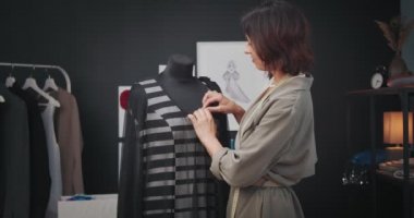Büyüleyici moda tasarımcısı yeni kıyafet koleksiyonu üzerinde çalışıyor.