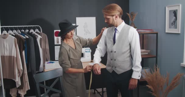 Diseñador competente midiendo hombre barbudo en atelier — Vídeo de stock