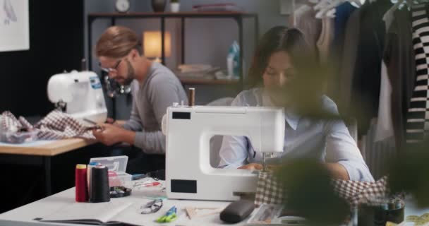 Diseñadores de moda que utilizan máquinas de coser en el trabajo — Vídeo de stock