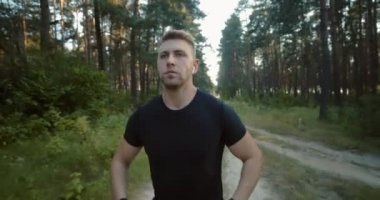 Yeşil ağaçlar arasında koşan aktif bir adamın ön görüntüsü