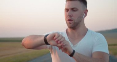 Açık havada koşarken derin derin nefes alan genç adam.