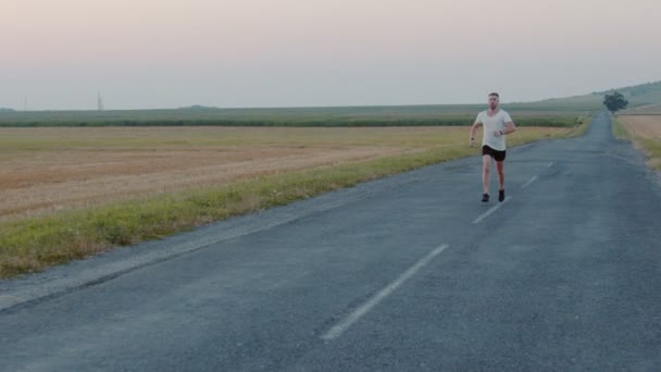 Atleta bonito fazendo exercícios regulares sobre a natureza — Vídeo de Stock