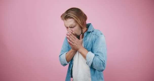 Bărbat strănut și tuse la studio cu fundal roz — Videoclip de stoc