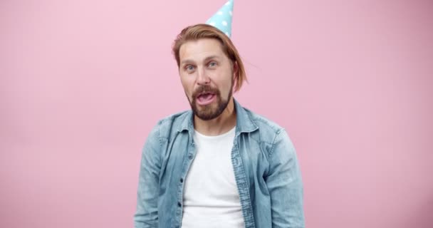 Щасливий бородатий чоловік у вечірній кепці насолоджується власним днем народження — стокове відео