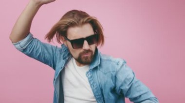 Güneş gözlüklü tatmin olmuş adam stüdyoda müzik dinliyor.