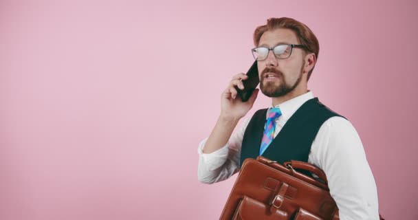 Hombre de negocios exitoso con maletín hablando en el teléfono inteligente — Vídeos de Stock