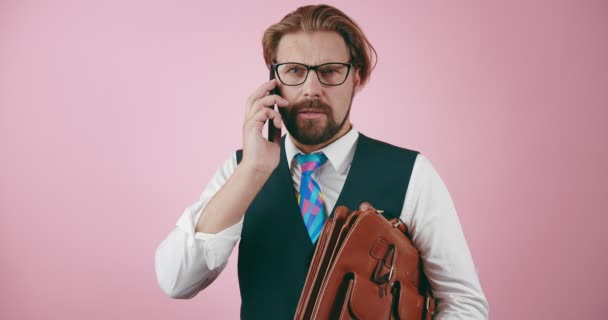 Bărbat cu barbă care ține servieta și vorbește pe smartphone — Videoclip de stoc