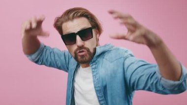 Günlük giysiler içinde mutlu bir adam duygusal olarak dans ediyor ve şarkı söylüyor.