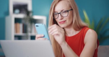 İşten izin alırken akıllı telefon kullanan gülümseyen kadın.