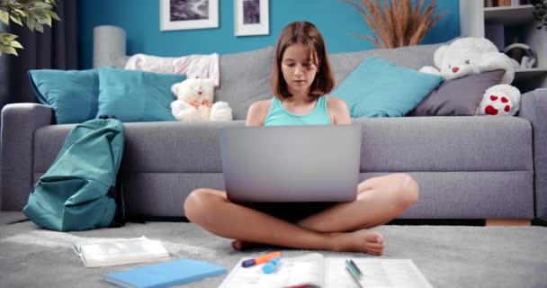 Симпатична жінка-підліток використовує ноутбук для навчання вдома — стокове відео