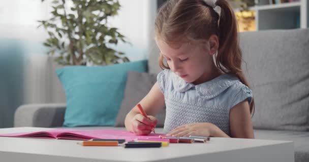 Niño feliz dibujo con lápices de colores en el álbum — Vídeo de stock