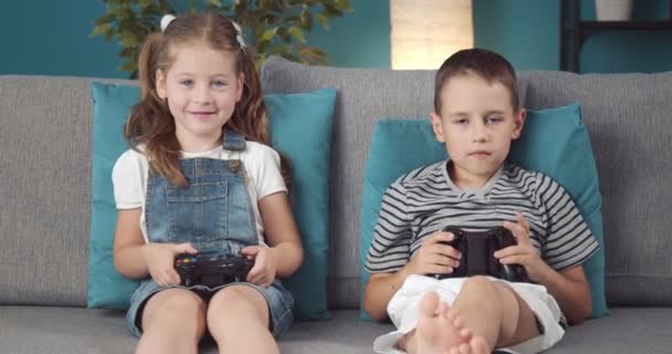 Joyeuse fille et garçon en utilisant des joysticks pour jouer à des jeux vidéo — Video