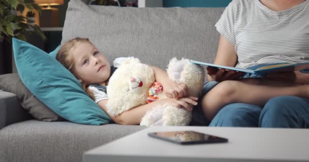 Lovely mother reading book to little daughter before sleep — Stock Video